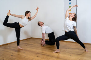 Foto 3 Personen praktizieren Vinyasa Flow Yoga